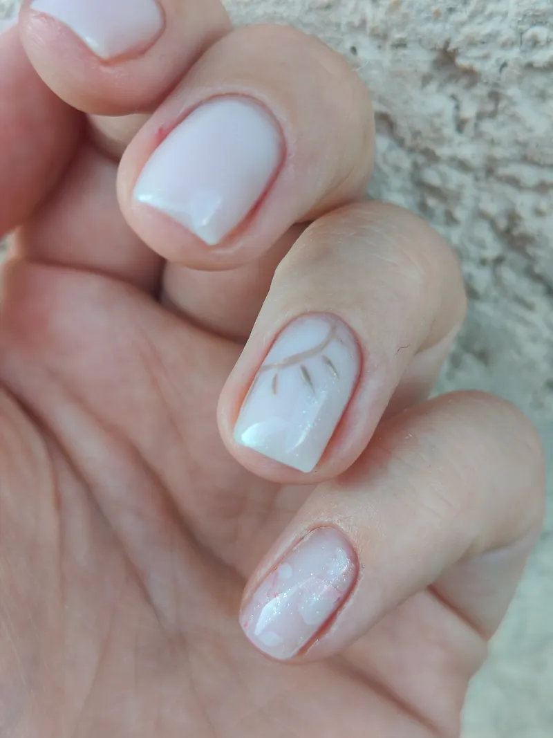 Renfort effet lait avec nail art feuillage discret et paillettes irisées — Maison M, Saint-Pierre-en-Faucigny